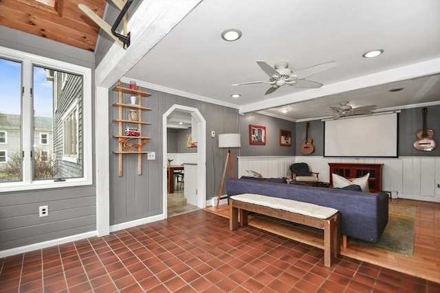 bedroom featuring baseboards, arched walkways, a decorative wall, crown molding, and recessed lighting
