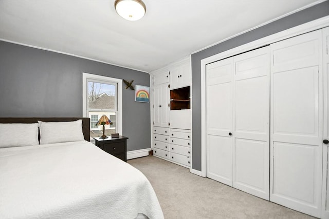 bedroom with crown molding, a closet, baseboards, and light carpet