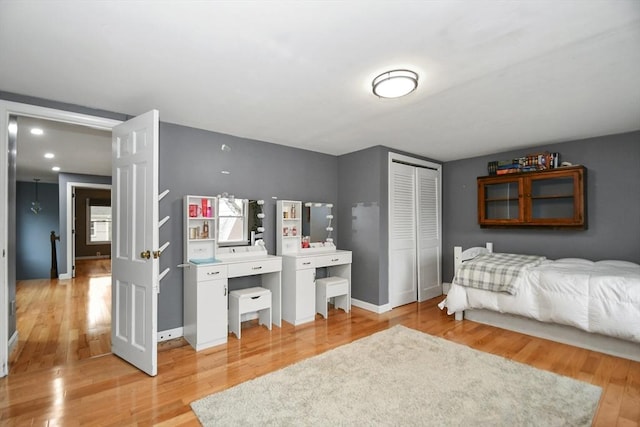 bedroom featuring a closet, light wood finished floors, and baseboards
