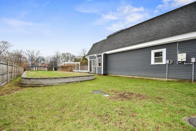 view of yard featuring a trampoline and fence