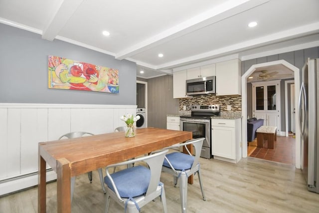 kitchen featuring decorative backsplash, a baseboard radiator, beamed ceiling, and appliances with stainless steel finishes