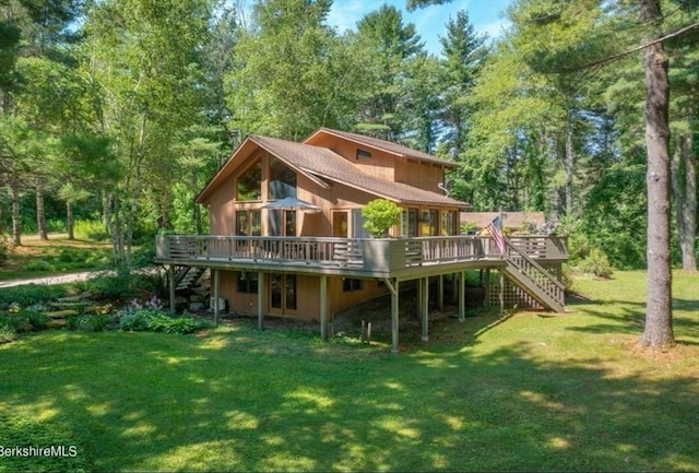 back of house with a wooden deck and a lawn