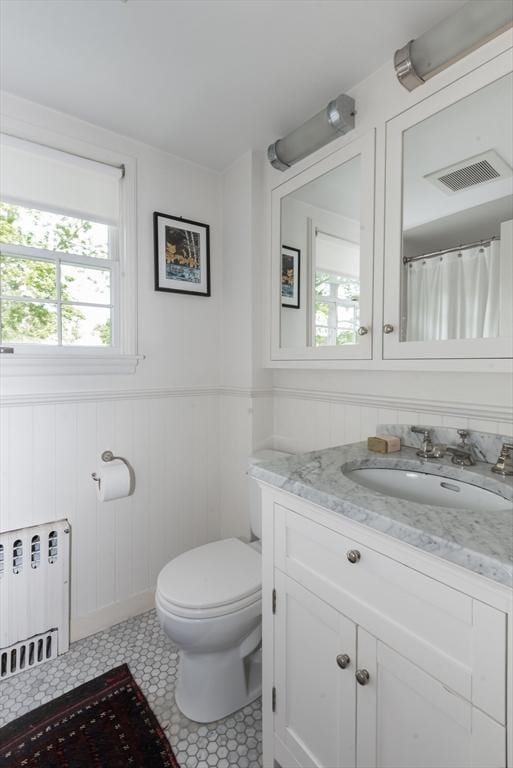 40 Stone Rd, Belmont, MA 02478 - full bathroom featuring radiator, vanity, toilet, plenty of natural light, and a wainscoted wall