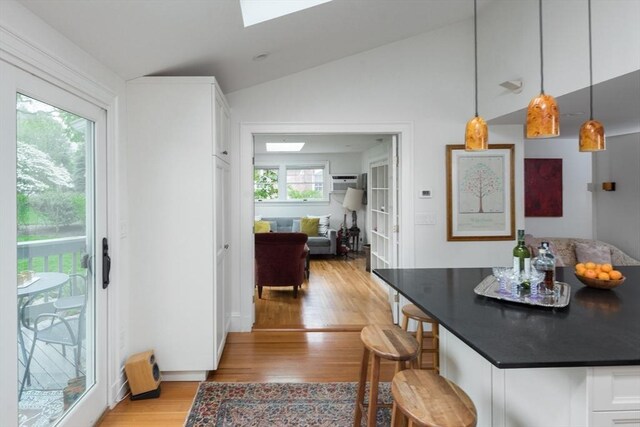 40 Stone Rd, Belmont, MA 02478 - dining area with vaulted ceiling, light wood-style flooring, a skylight, and a wall mounted AC
