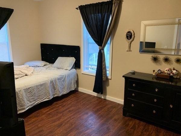 bedroom with wood finished floors and baseboards