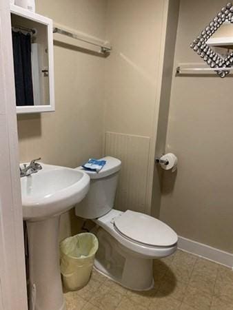 full bathroom with toilet and baseboards