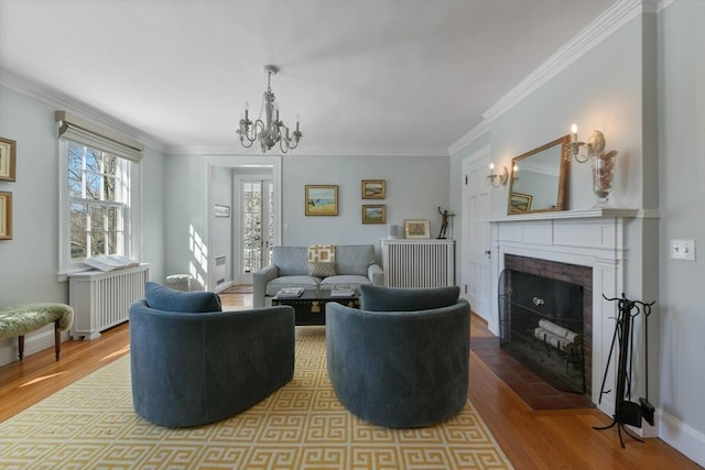living room featuring crown molding, an inviting chandelier, radiator, and wood finished floors
