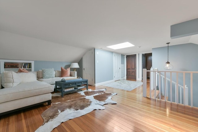 living room with light wood-type flooring and lofted ceiling with skylight