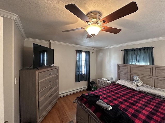 bedroom with a baseboard heating unit, wood finished floors, crown molding, a ceiling fan, and a textured ceiling