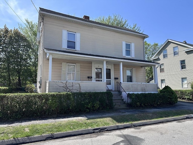 view of front of home with covered porch and a chimney