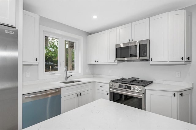 1514 Gorham St Unit 2, Lowell, MA 01852 - kitchen featuring stainless steel appliances, a sink, light stone counters, white cabinets, and recessed lighting