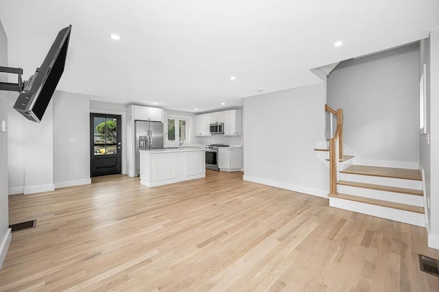 1514 Gorham St Unit 2, Lowell, MA 01852 - unfurnished living room featuring baseboards, light wood-style floors, stairs, and recessed lighting