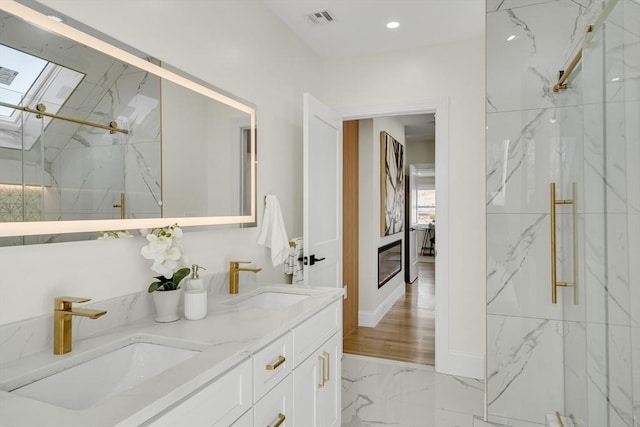 bathroom with visible vents, marble finish floor, a sink, and a marble finish shower