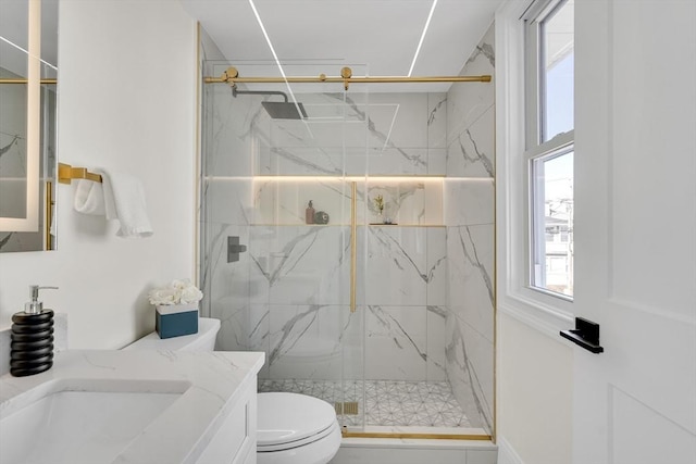 full bathroom with vanity, a marble finish shower, and toilet