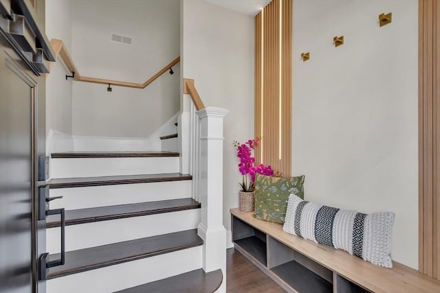 stairway featuring visible vents and wood finished floors