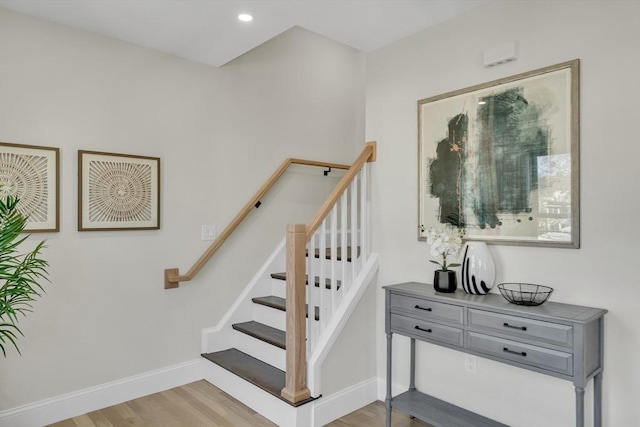 stairs with recessed lighting, wood finished floors, and baseboards