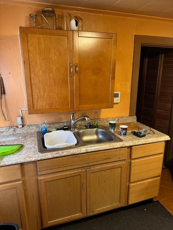 interior space with tile patterned flooring, sink, and ornamental molding