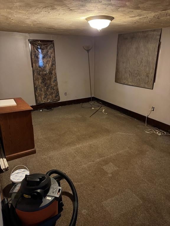 empty room with carpet and a textured ceiling