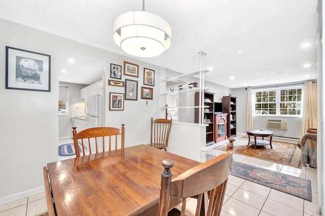 dining room featuring a wall unit AC and light tile patterned floors