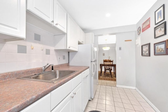 kitchen with sink, light tile patterned floors, pendant lighting, dishwasher, and white cabinetry