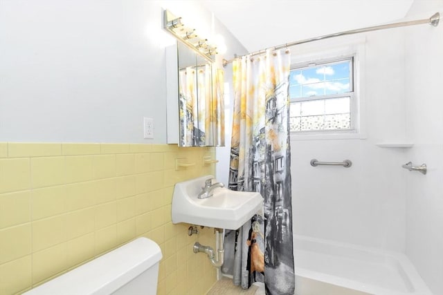 full bathroom featuring sink, shower / tub combo with curtain, tile walls, and toilet