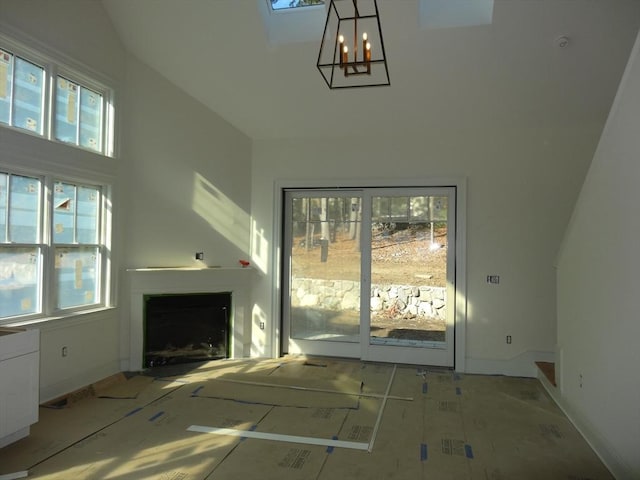 unfurnished living room featuring a notable chandelier and a high ceiling