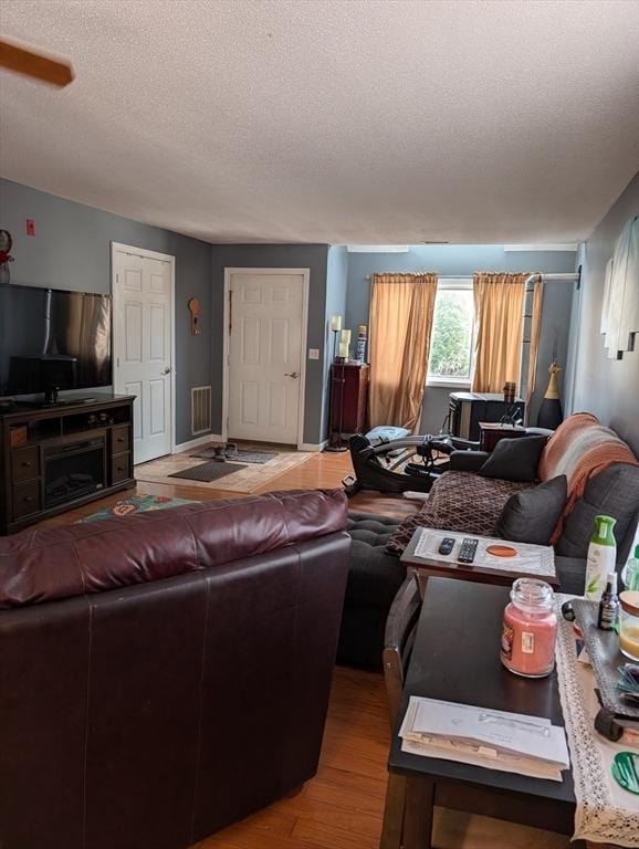 living room with hardwood / wood-style floors and a textured ceiling