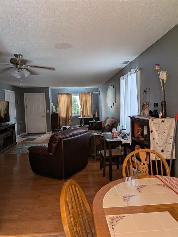 dining room with hardwood / wood-style floors and a textured ceiling