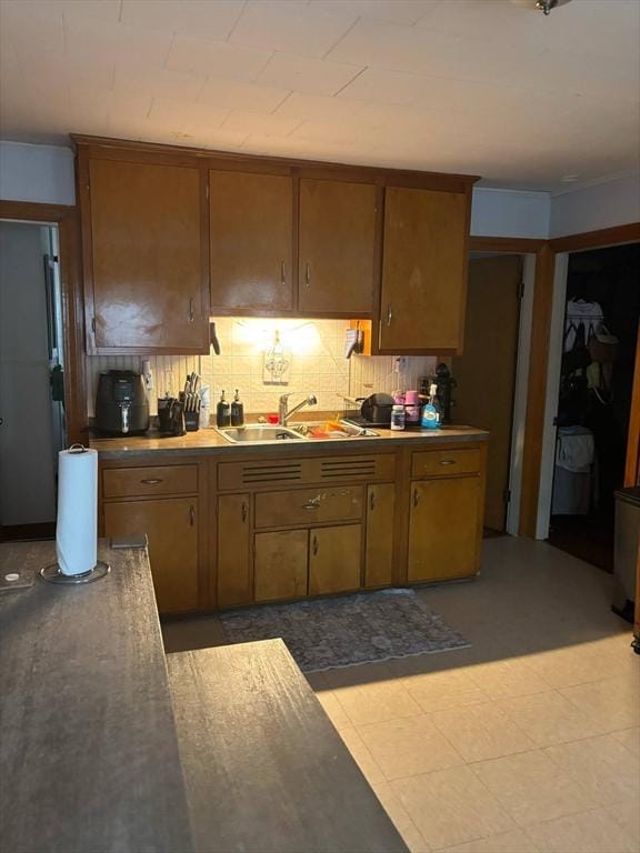 12 Woodmont St, Westfield, MA 01085 - kitchen with a sink, backsplash, and brown cabinetry