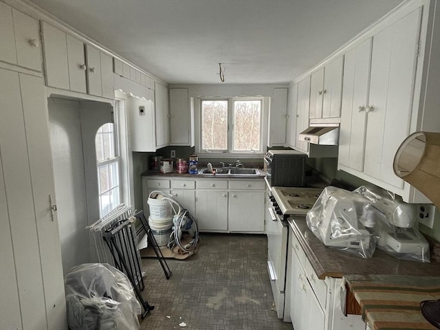 kitchen featuring sink, white range with gas stovetop, and white cabinets