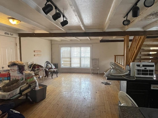 misc room with light hardwood / wood-style flooring, beamed ceiling, and track lighting