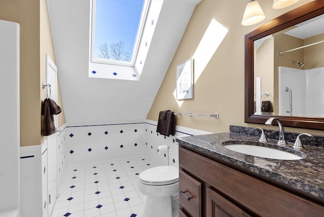 bathroom with vanity, a skylight, tile patterned floors, and toilet