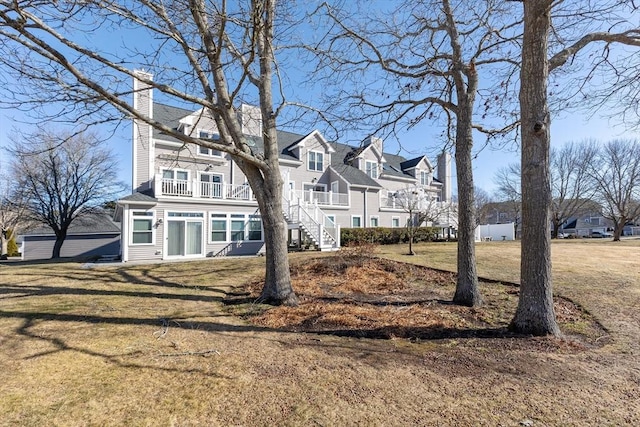 view of front of home with a balcony and a front yard