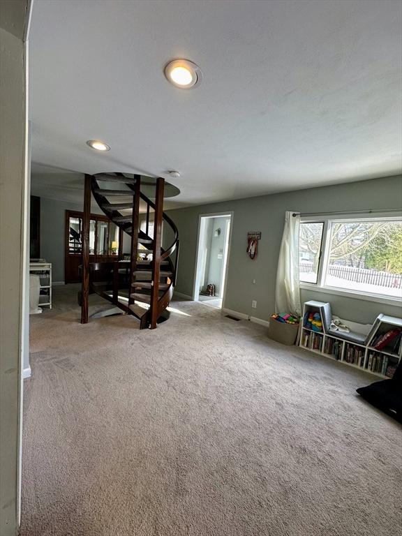 carpeted living room featuring baseboards