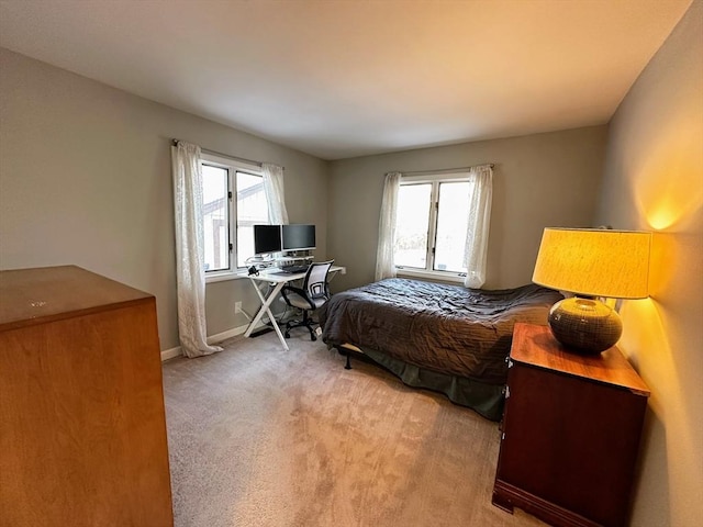 bedroom with baseboards, multiple windows, and light carpet