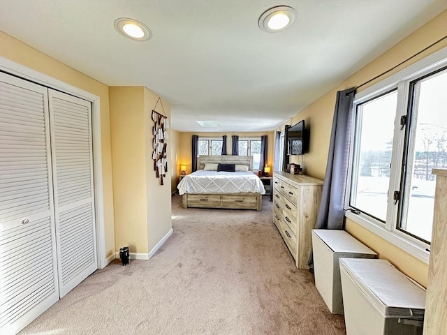 bedroom featuring baseboards, a closet, and light carpet