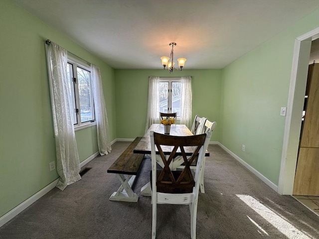 dining area with baseboards, an inviting chandelier, dark carpet, and visible vents