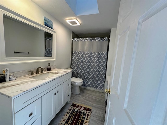 full bathroom featuring vanity, a shower with shower curtain, and toilet