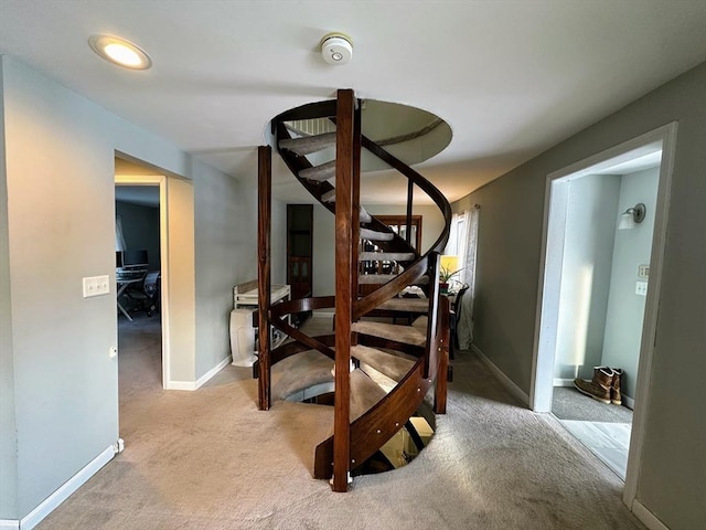 interior space featuring baseboards, light carpet, and stairway