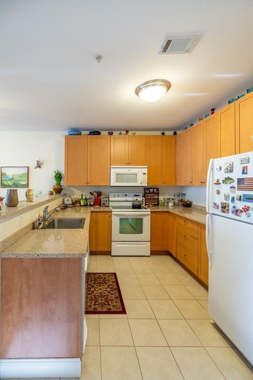 kitchen with sink, light stone counters, kitchen peninsula, white appliances, and light tile patterned flooring