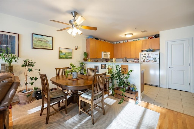 dining area with ceiling fan and light hardwood / wood-style floors