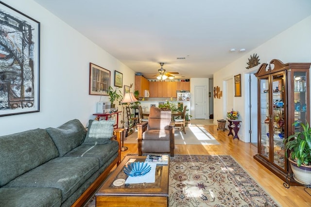 living room featuring ceiling fan and light hardwood / wood-style flooring