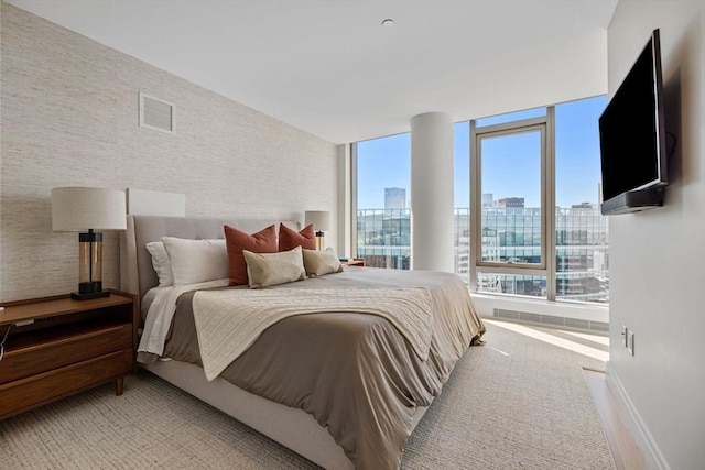 bedroom with baseboards, light carpet, and visible vents