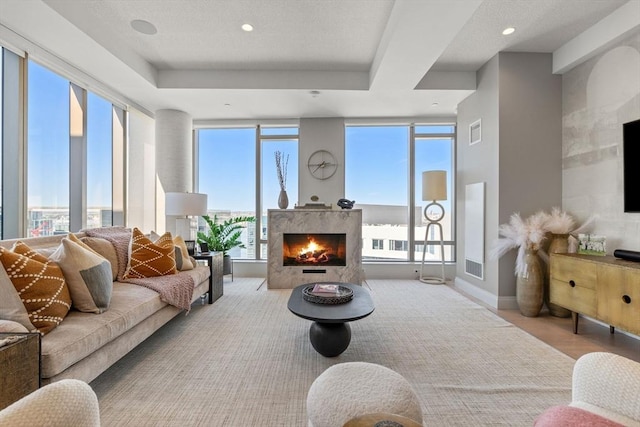 living area featuring recessed lighting, visible vents, and a high end fireplace