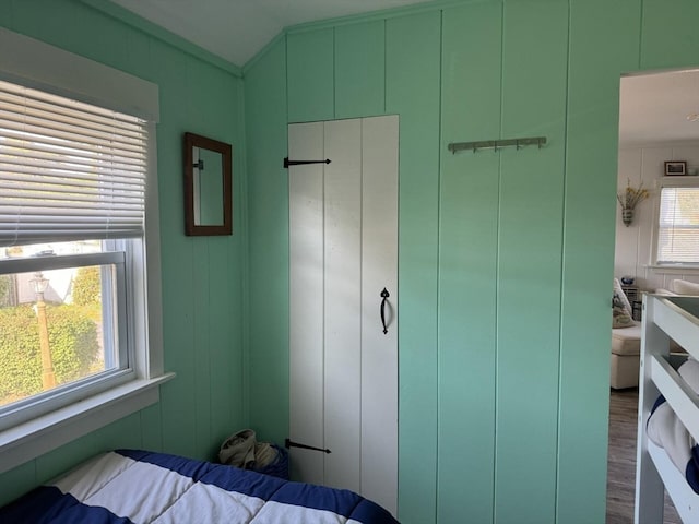 bedroom with wood walls and dark hardwood / wood-style flooring