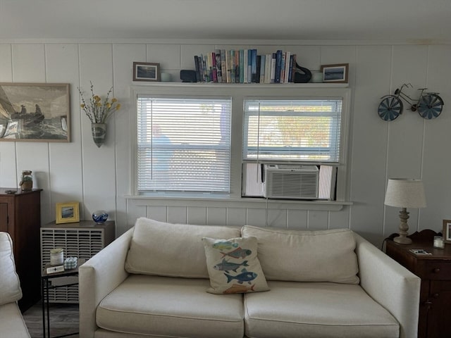 living room featuring cooling unit, wood-type flooring, and a wealth of natural light