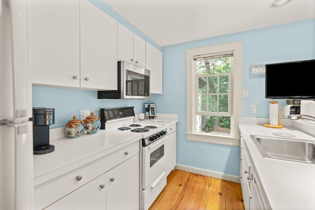 kitchen featuring white cabinetry, sink, white electric stove, and light wood-type flooring