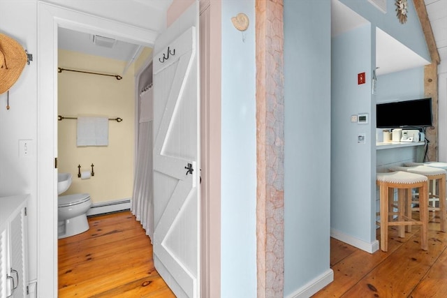 bathroom featuring a baseboard radiator, toilet, and hardwood / wood-style floors