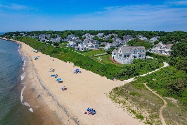 birds eye view of property with a water view and a beach view