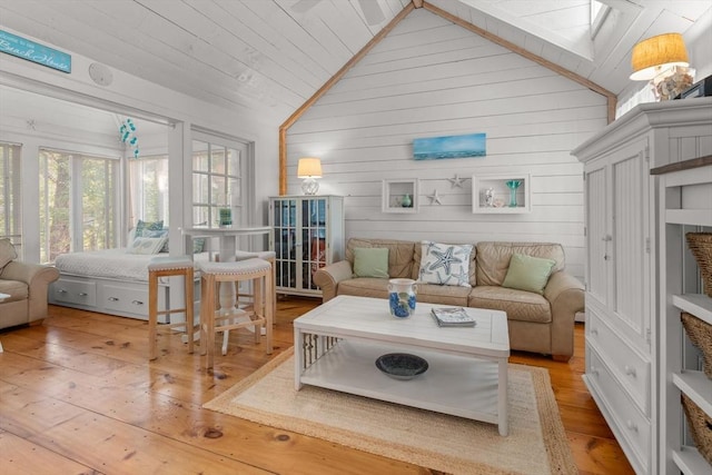 living room featuring lofted ceiling with skylight and hardwood / wood-style floors